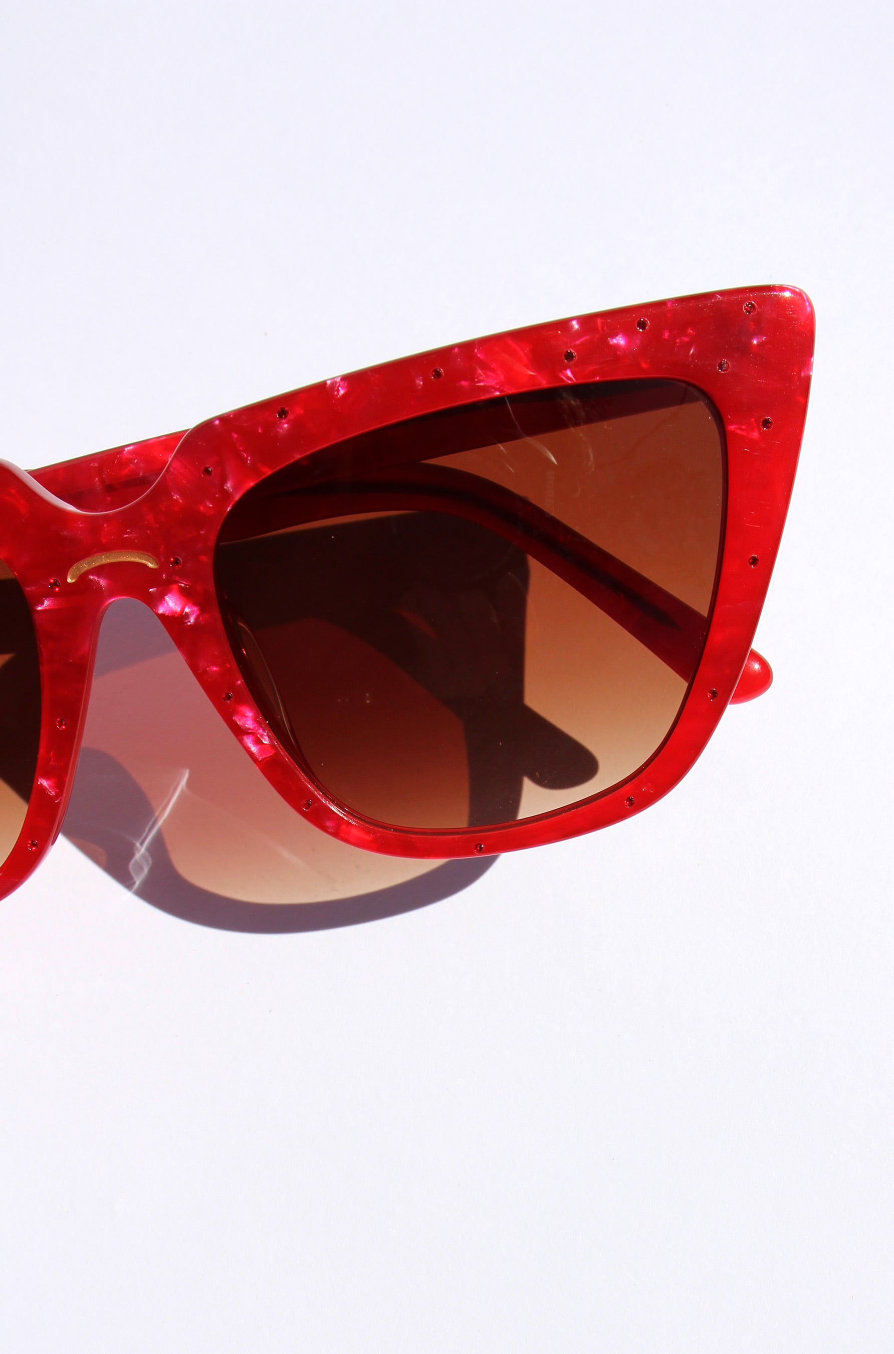 Rubie ~ Sharp cat-eye sunglasses in red marble with micro crystal detailing