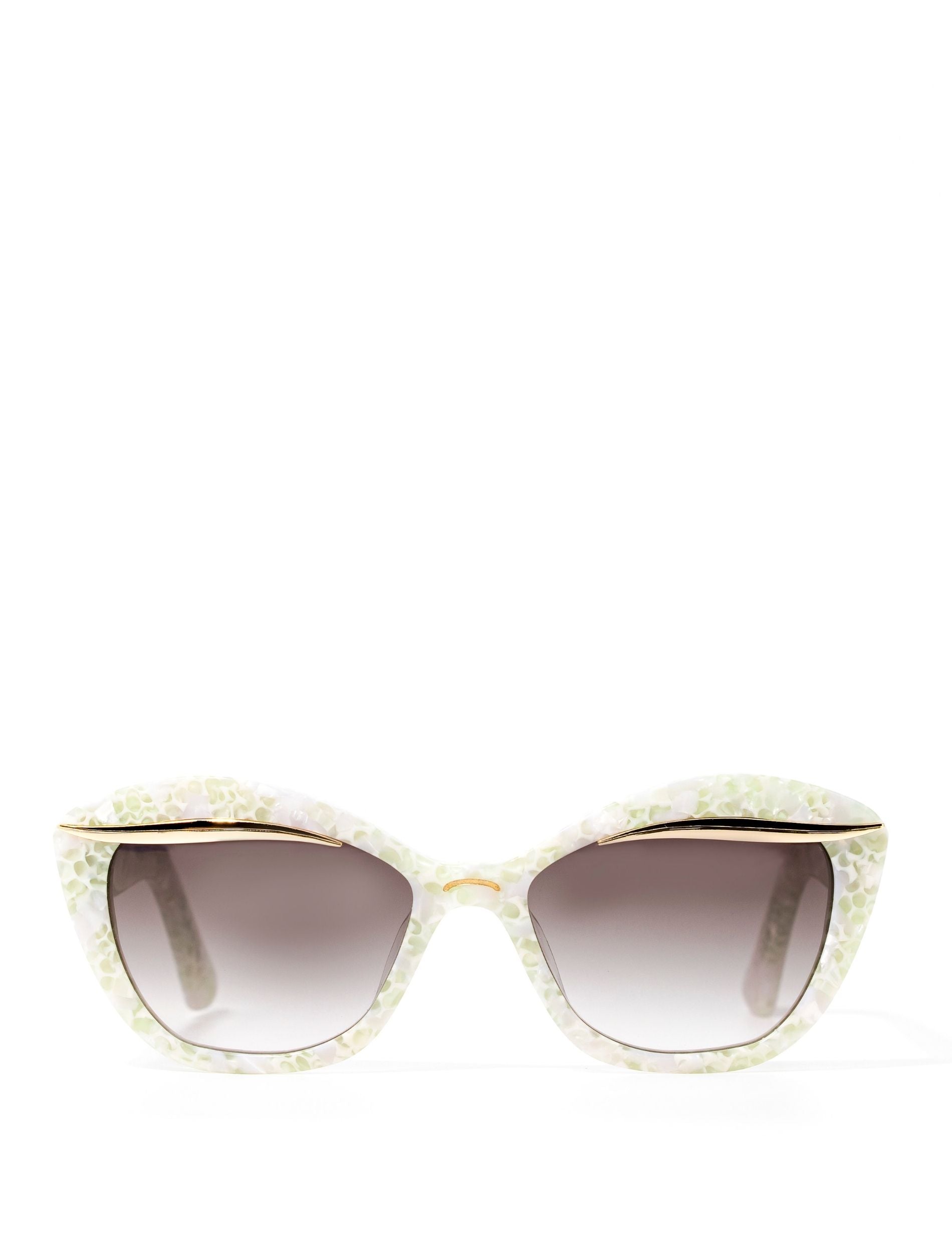 Front view of a stylish pair of sunglasses adorned with a gold flick along the upper lense and a subtle white pearl frame, set against a white backdrop. Featuring a dark grey gradient lense
