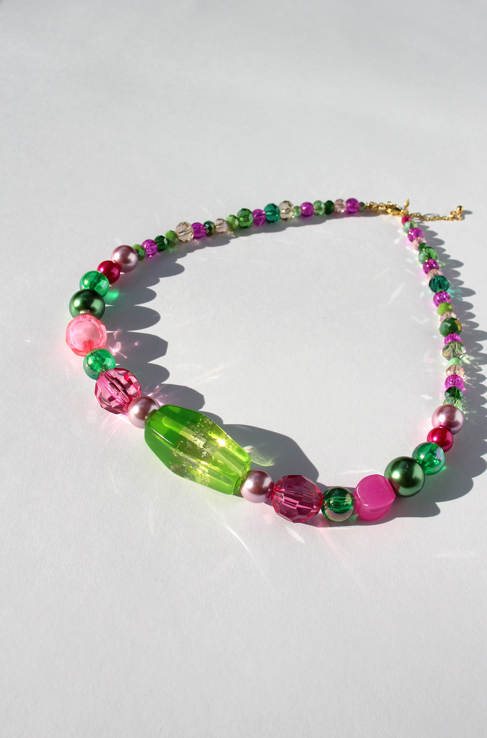 GUAVA GLOW ~ Handmade statement necklace featuring a green glitter centrepiece with emerald green and fuchsia beads