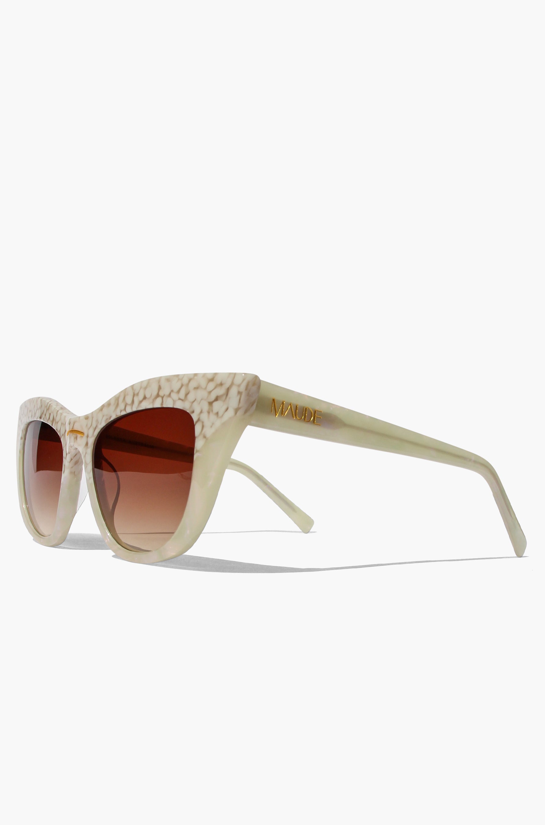Beige sunglasses with a textured frame on a white background