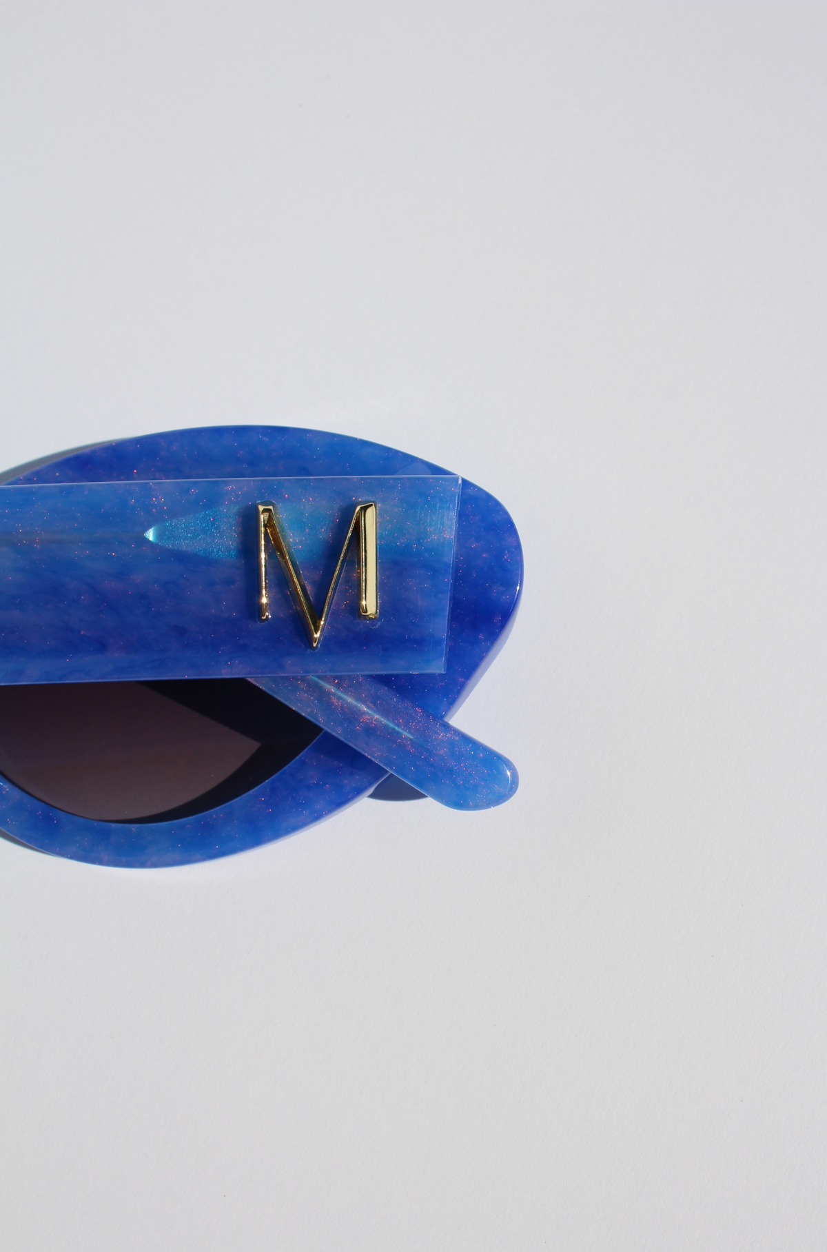 AZURIA ~ Oval shaped sunglasses in a luminous imperial blue with pink shimmer