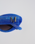 AZURIA ~ Oval shaped sunglasses in a luminous imperial blue with pink shimmer