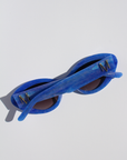 AZURIA ~ Oval shaped sunglasses in a luminous imperial blue with pink shimmer