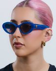 AZURIA ~ Oval shaped sunglasses in a luminous imperial blue with pink shimmer