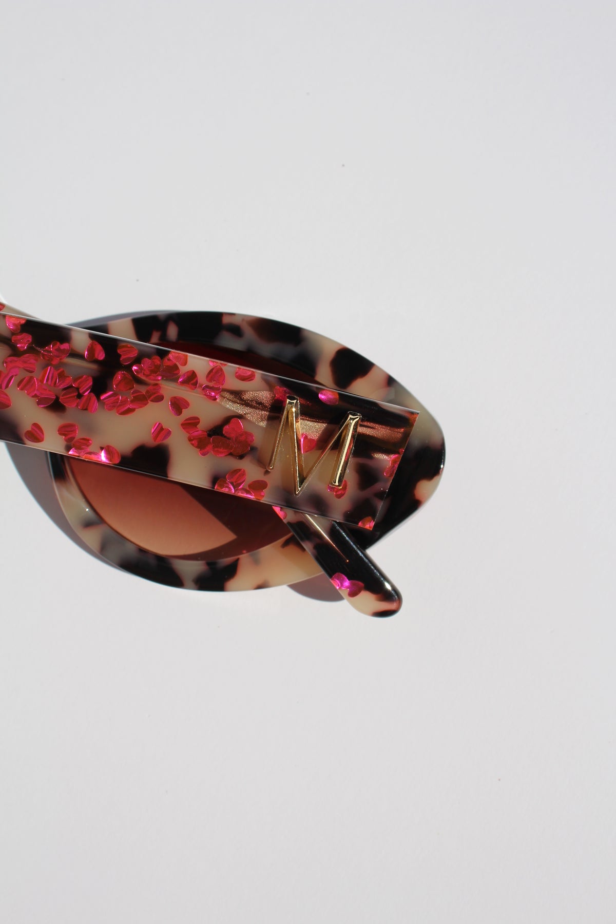 JEWELISSA ~ Oval shaped sunglasses in tortoiseshell acetate sprinkled with vibrant pink hearts