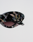 ONYX NOIR ~ Oval shaped sunglasses in marbled black and blush with shimmering turquoise acetate
