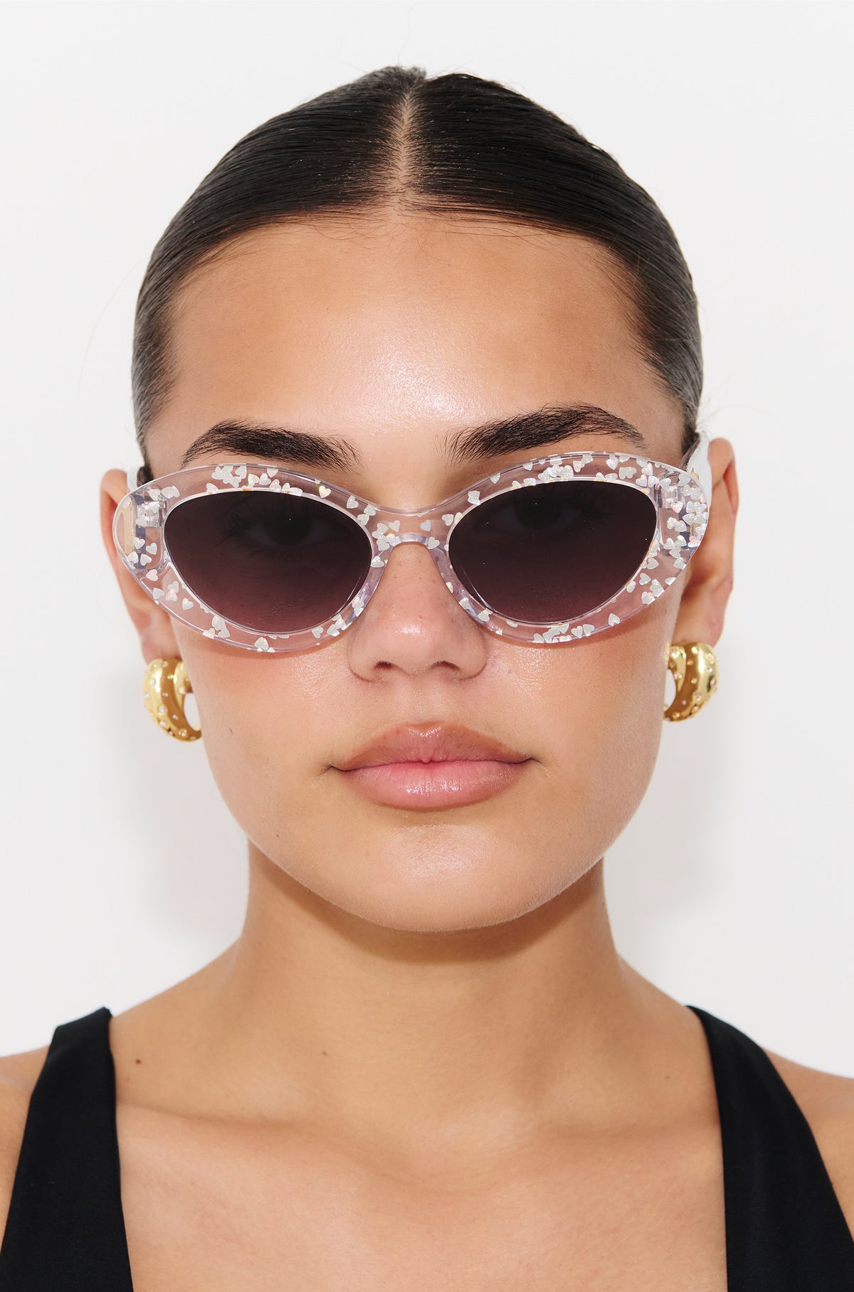 SILVELLE ~ Oval shaped sunglasses in clear acetate sprinkled with iridescent silver love heart sequins