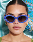 AZURIA ~ Oval shaped sunglasses in a luminous imperial blue with pink shimmer