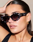ONYX NOIR ~ Oval shaped sunglasses in marbled black and blush with shimmering turquoise acetate
