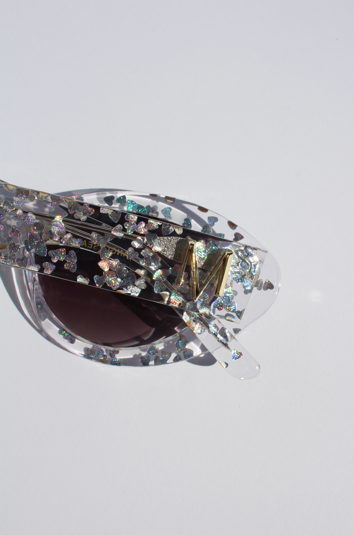 SILVELLE ~ Oval shaped sunglasses in clear acetate sprinkled with iridescent silver love heart sequins