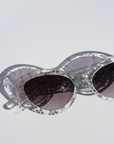 SILVELLE ~ Oval shaped sunglasses in clear acetate sprinkled with iridescent silver love heart sequins