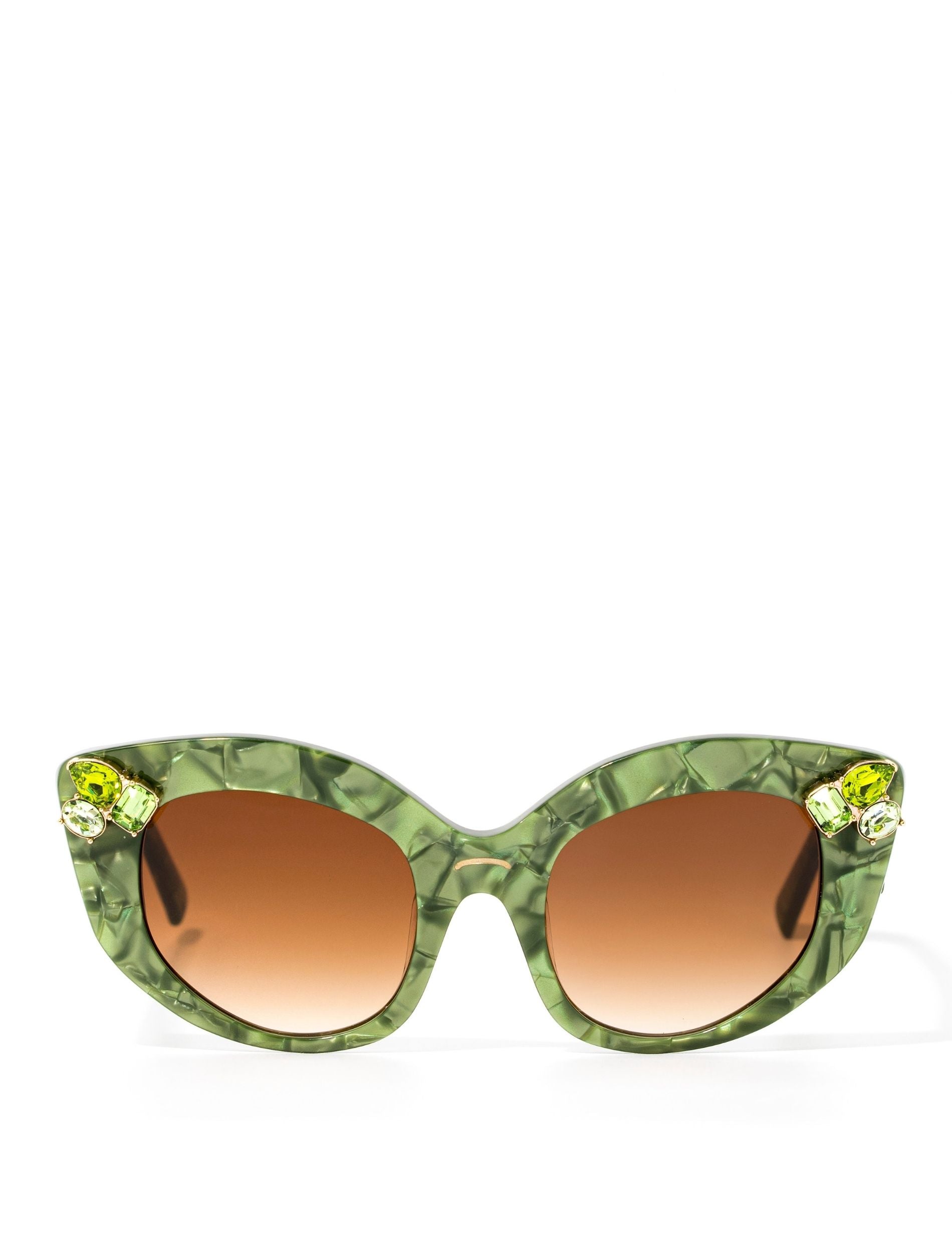 Front view of stunning cat eye sunglasses crafted with a green pearlescent look,  featuring gemstone embellishments on the upper corners of the frame and a brown gradient lense. Set against a white backdrop