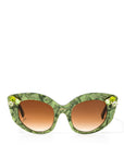 Front view of stunning cat eye sunglasses crafted with a green pearlescent look,  featuring gemstone embellishments on the upper corners of the frame and a brown gradient lense. Set against a white backdrop