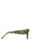 Front view of stunning cat eye sunglasses crafted with a green pearlescent look,  featuring gemstone embellishments on the upper corners of the frame. Set against a white backdrop