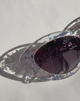 SILVELLE ~ Oval shaped sunglasses in clear acetate sprinkled with iridescent silver love heart sequins
