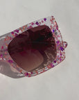 GLITTERATI ~ Square shaped sunglasses in silver glitter with a confetti of pink hearts and peach sequins