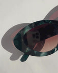 GLOWELLA ~ Oval shaped sunglasses in dark green with shimmering emerald tort